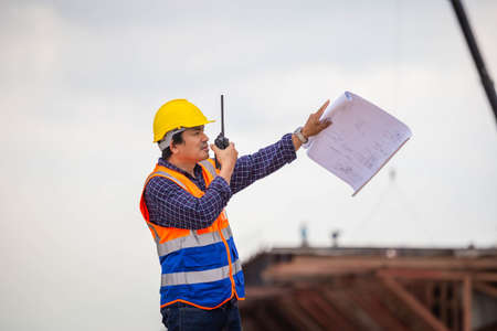 Construction engineer checking project at the building site, Architect with a blueprints at a...