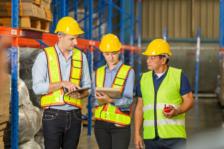 Manager and supervisor taking inventory in warehouse, Foreperson making plans with warehousemen, Workers team working in warehouseの写真素材