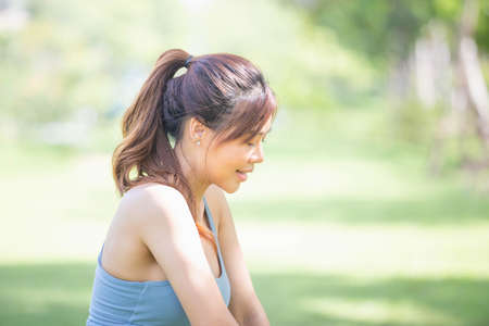 Cheerful sportswoman in the green park, Smile girl exercising outdoors, Healthy lifestyle conceptsの写真素材