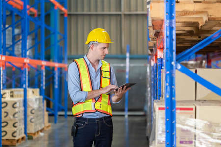 Warehouse worker with digital tablet checking inventory in factory warehouse, Workers working in warehouseの写真素材