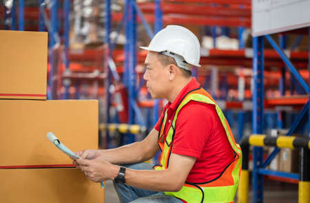 Warehouse workers checking inventory, Forman worker working in factory warehouseの写真素材