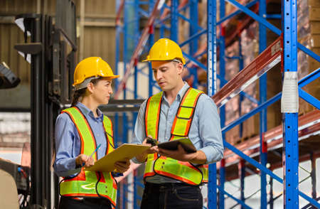 Workers working in warehouse, Manager and supervisor taking inventory in warehouse, Female foreperson making plans with warehousemenの写真素材