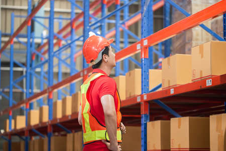 Warehouse worker checking inventory in warehouse, Forman worker working in factory warehouseの写真素材
