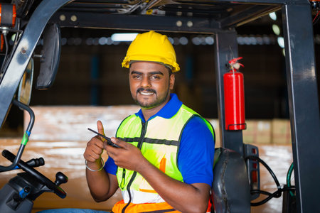 Forklift driver showing thumbs up, Worker man in hardhat and safety vest sitting in container...
