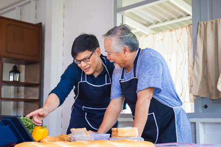 Selective focus at son, Middle-aged son, and senior Asian father cooking together in the kitchen, Happiness family, and Father's day conceptsの写真素材