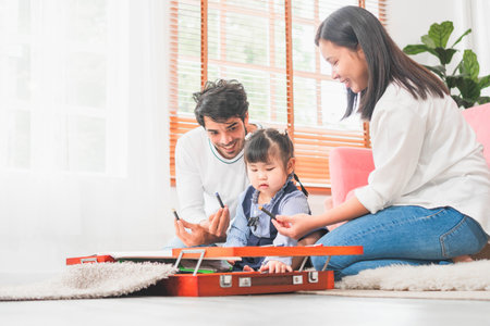 Child girl with young family having fun in the living room, Parents and daughter playing at home, Family spending time in the living roomの写真素材