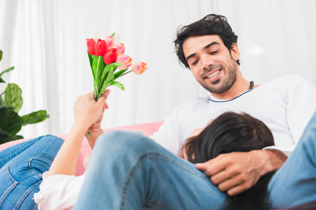 Couple relaxing on couch at home, Woman and her husband on the couch in the living room, Mid adult man having fun with his wife on the couchの写真素材