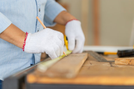 Carpenter working with equipment on wooden table in wood workshop, man doing woodwork in carpentry shopの写真素材