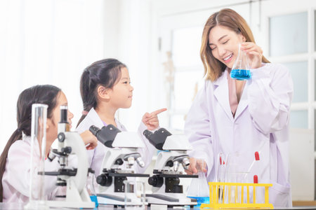 Elementary science class, Cheerful kids girl with teacher scientist in school laboratory, Science laboratoryの写真素材