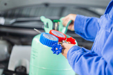 Air Conditioning Repair, Repairman holding monitor tool to check and fixed car air conditioner system, Technician check car air conditioning system refrigerant rechargeの写真素材