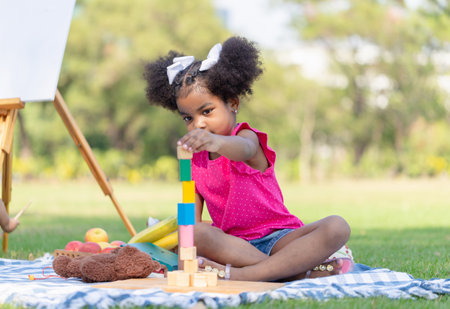 Cute little girl play toy at the garden, Child girl playing with little wooden toy outdoorの写真素材