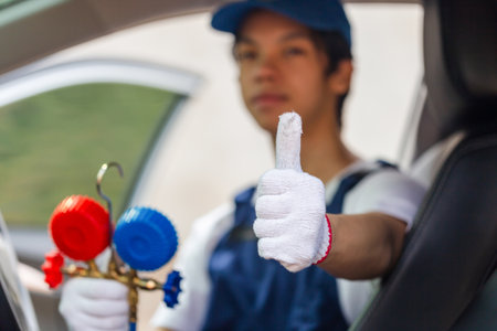Technician showing thumbs up and holding monitor tool to check and fixed car air conditioner system, Repairman check car air conditioning system, Air Conditioning Repairの写真素材