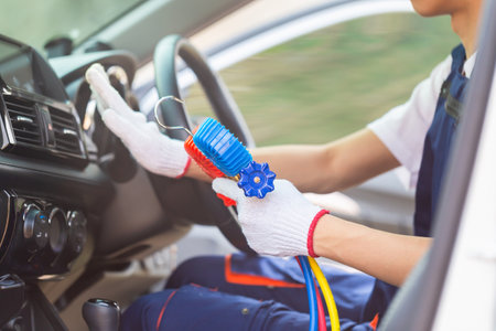 Repairman holding monitor tool to check and fixed car air conditioner system, Technician check car air conditioning system refrigerant recharge, Air Conditioning Repairの写真素材