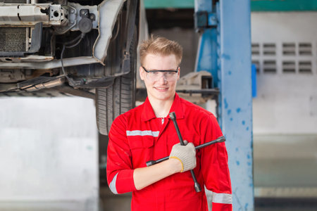 Cheerful the mechanic man in repair garage, Technician man working in auto repair shop, Car repair and maintenance conceptsの写真素材