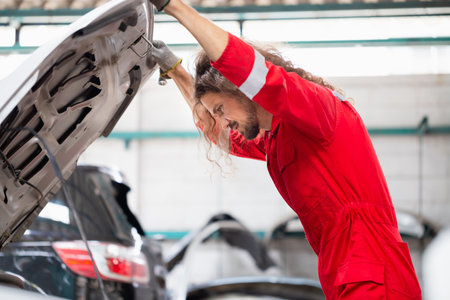 Car mechanic in repair garage, Technician man working in auto repair shop, Car repair and maintenance conceptsの写真素材