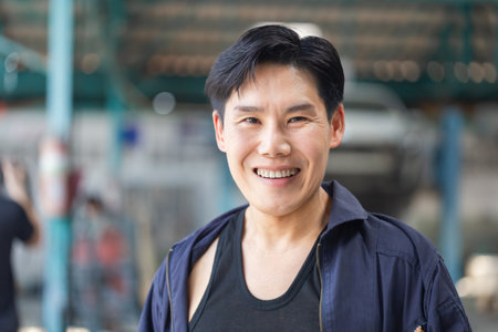 Cheerful the mechanic man in repair garage, Technician man working in auto repair shop, Car repair and maintenance conceptsの写真素材