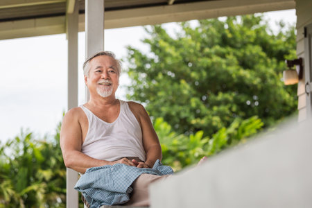 Senior Asian man sitting relax on the terrace, Asian elder man sitting at the balconyの写真素材