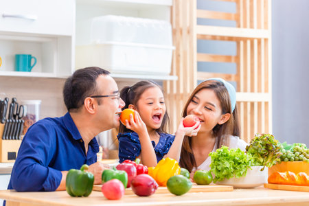 Father mother and daughter cooking together in the kitchen, Happy Asian family conceptsの写真素材