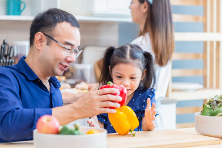 Father mother and daughter cooking together in the kitchen, Happy Asian family conceptsの写真素材
