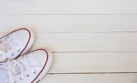 Flat lay top view of sneakers on white wooden background with copy spaceの写真素材