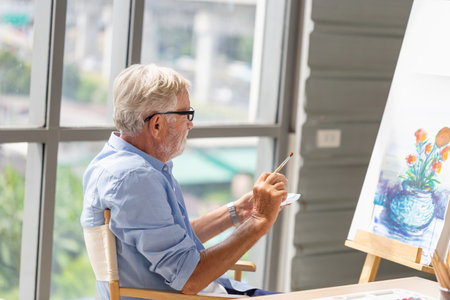 Senior man painting on canvas at home, Elderly man painting on a canvas, Happy retirement conceptsの写真素材