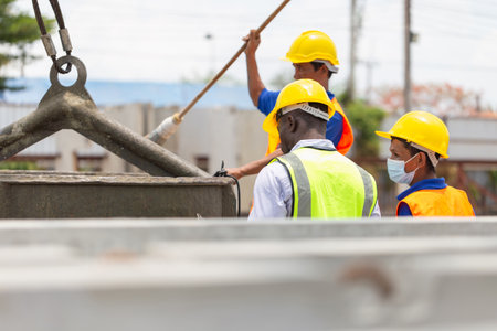 Foreman and worker team checking project at the precast factory site, Engineer man and builders in hardhats discussing on construction siteの写真素材