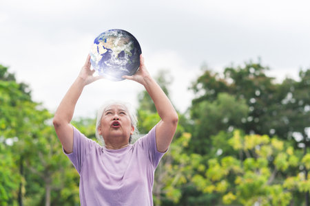 Earth Day Concept, Senior woman holding the globeの写真素材