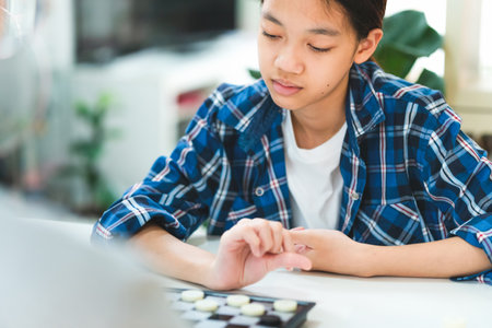 Asian teenage girl and boy playing board game, Asian brother and sister relaxing hobbies playing a...