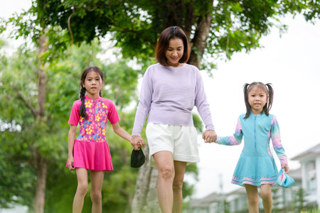 Mother and daughter go to swimming pool, Asian kid girls in swimsuit with mom walking outdoor