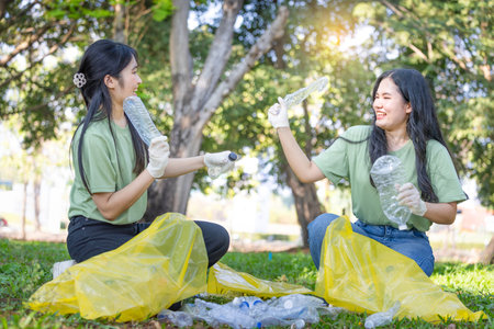Young Woman Team Cleaning Up Litter for Environmental Conservation, Teamwork for a Greener Planet,  Female Volunteers Picking Up Trashの写真素材