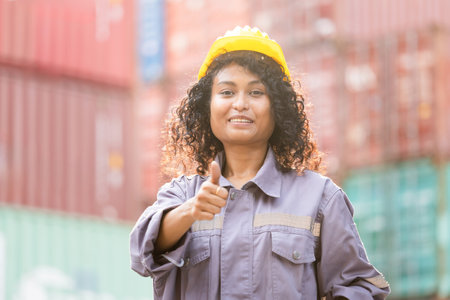 Smiling Female Logistics Professional Inspecting Containers and Giving Thumbs Up Outdoors, Woman with Thumbs Up in Industry Containers Cargoの写真素材