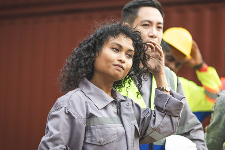 Engineer and foreman workers team working in logistic terminal of container cargo, Diverse...