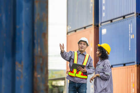 Female supervisor in safety gear and foreman worker in hardhat checking and control loading...