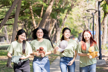 Happy Volunteers Helping the Community with Donations, Smiling Young Women Volunteers Team Engaged in Donation Activities Outdoorsの写真素材