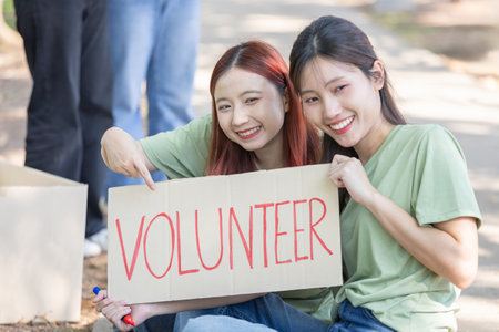 Happy Young Volunteers Helping the Community with Donations, Smiling Female Volunteers Engaged in Donation Activities Outdoorsの写真素材