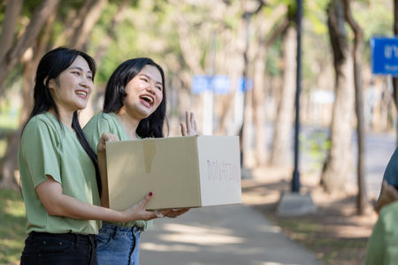Happy Volunteers Helping the Community with Donations, Smiling Volunteers Engaged in Donation Activities Outdoorsの写真素材