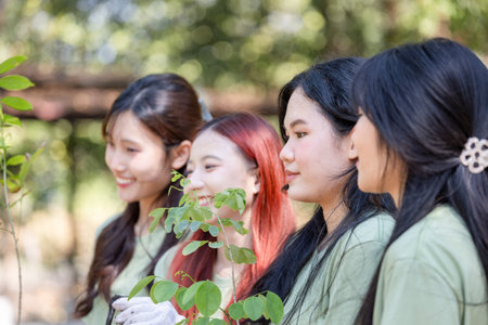 Young Asian woman team volunteer planting trees, female volunteer team in park for charity event, Group of Female volunteer people team preparing to plant treesの写真素材