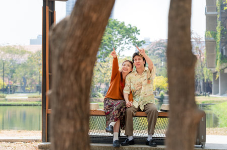 Happy Couple Resting in Park on a Sunny Day, Joyful Young Asian People in a Green Park Settingの写真素材