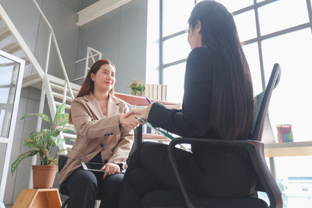Business handshake. Asian business people making a handshake, Happy business woman manager handshaking greeting client in officeの写真素材