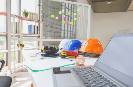Group of safety helmet on the desk of architectural at construction site, Engineer and teamwork conceptsの写真素材