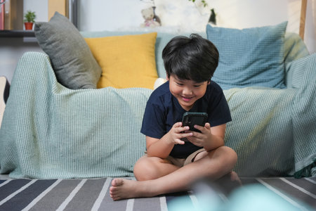 Boy Using Mobile Phone at Home, Asian Child Boy Playing Game with Smartphone