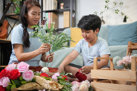 Mother and Son Arranging Flowers Together at Home, Family Bonding Through Flower Arranging Activity, Happy Mother and Child Making Floral Decorations Indoorsの写真素材
