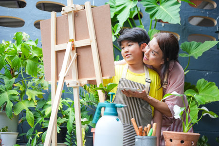 Mother and Son Painting Together in Garden, Kid Artist and Mom Drawing with Colorful Paintsの写真素材