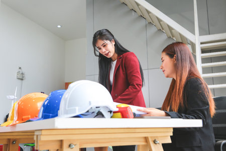 Engineer and architecture team meeting and brainstorming together at project site, Young women discussing ideas and planning strategy in officeの写真素材