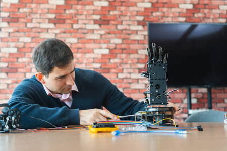 Robotics Engineer Working on Advanced Prosthetic Arm, Man Assembles Bionic Hand Prototype, Scientist...