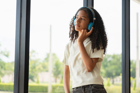 Young Girl Enjoying Relaxing Time and Audio Content, Portrait of a Pensive Preteen with Curly Hair...