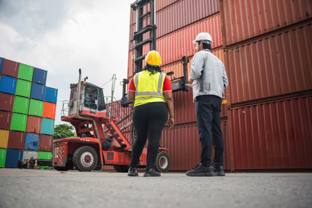 Diverse Logistics Engineers Observing Reach Stacker and Stacked Cargo Containers at Port Terminal,...