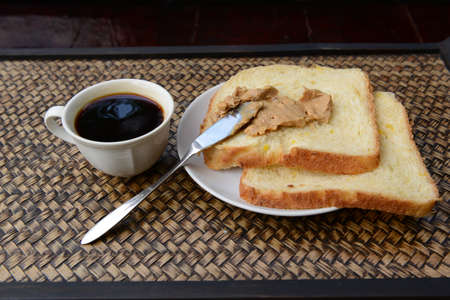Peanut butter on homemade bread with coffee. Chill out time in countryside of Thailand