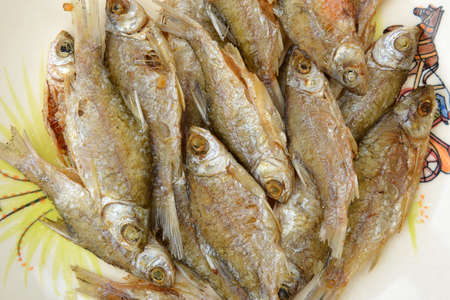 Fried fish lays on a white plate. Thai food in countryside.の写真素材