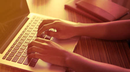 man working at home office hand on keyboard close up in sunsetの写真素材
